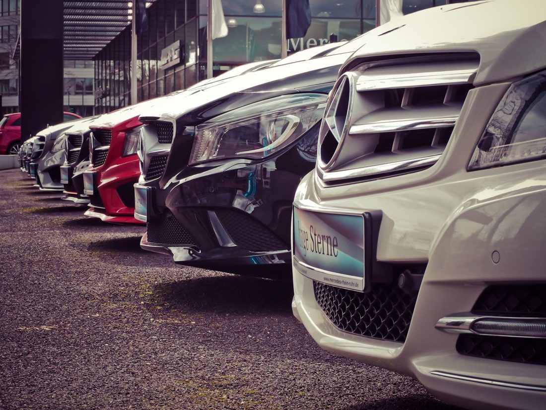 A row of late-model sedans lined up on a dealer lot